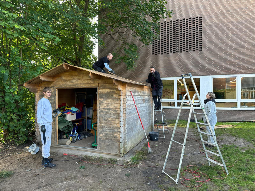 Teilnehmer des Social Days reparieren eine Holzhütte auf dem Gelände der Evangelischen Schule Burgwedel.