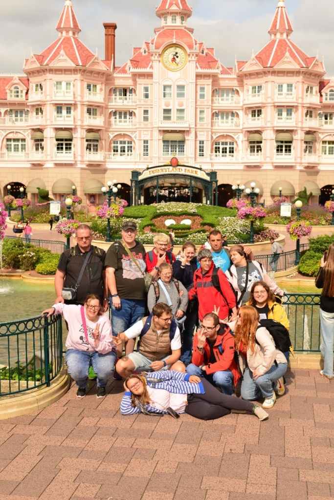 Bewohner aus dem Wohnangebot der Pestalozzi-Stiftung posieren vor dem Eingang des Disneyland Paris.