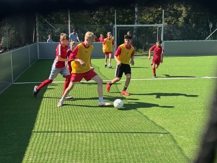 Spieler der Fußballmannschaften laufen auf dem Spielfeld dem Ball hinterher.