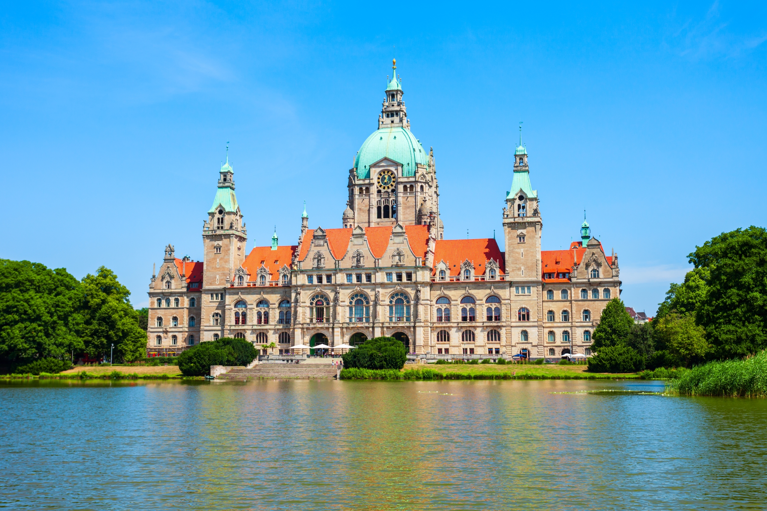 Das neue Rathaus von Hannover, fotografiert von der Rückseite, mit dem Teich des Maschparks im Vordergrund.